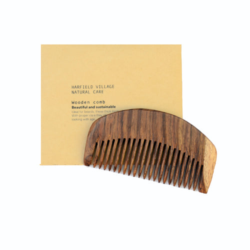 A wooden comb sits on top of a beige envelope