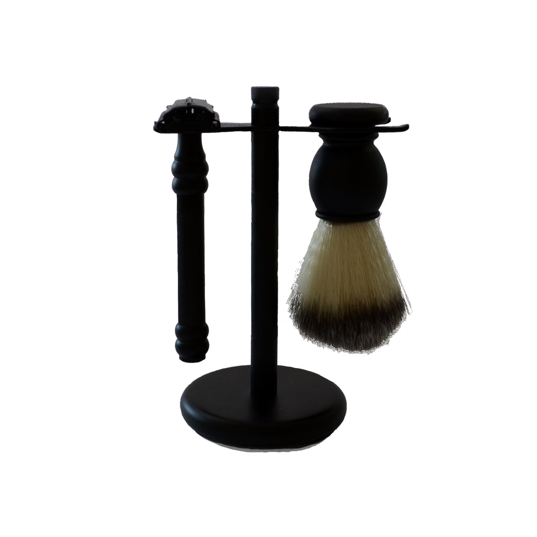 A black stand with a black razor and a black handled shaving brush hanging from it